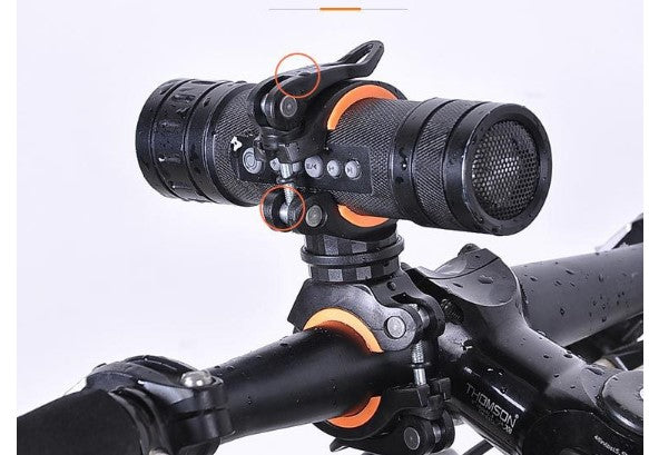 Black bicycle light mounting bracket on handlebar with orange inner ring accents