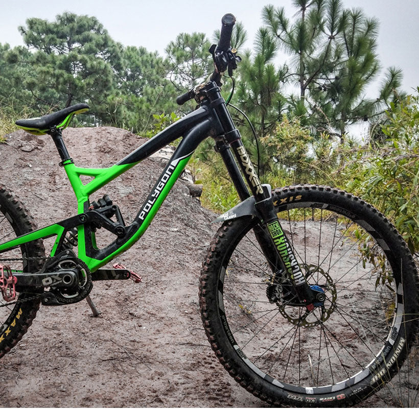 Front mountain bike with green frame and wheel-mounted carbon mudguard for off-road