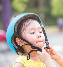 Blue toddler helmet with chin strap and close-up child wearing it