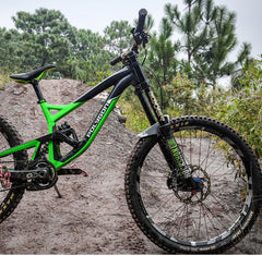 Front mountain bike with green frame and wheel-mounted carbon mudguard for off-road