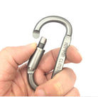 Silver aluminum carabiner clip held in hands with spring latch and gate