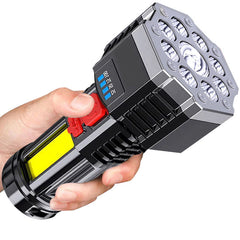 Black rechargeable LED flashlight held in hand with red switch and side LEDs
