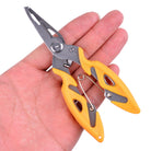 Fishing hook remover pliers held in hand, yellow grips and silver jaws