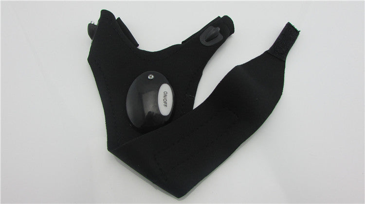 Pair of black LED flashlight gloves laid flat with round light module