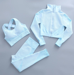 Women's light blue fitness set with zip mock-neck jacket, sports bra, high-waist leggings.